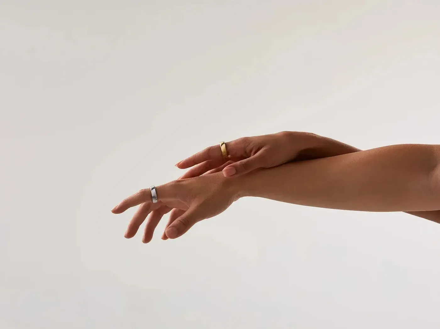Deux mains portant la RingConn Gen 3, l'une en finition or, l'autre en argent